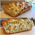 Close-up of a golden-brown Italian herb and cheese bread loaf showing its fluffy, cheesy interior.