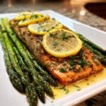 A perfectly cooked salmon fillet served with roasted asparagus and topped with lemon slices, ideal for anti-inflammatory dinners.