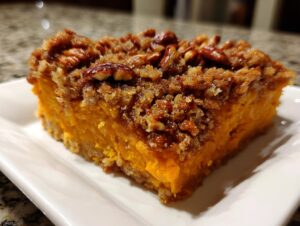 A rich, orange slice of southern sweet potato casserole topped with a crunchy pecan streusel.