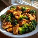 Close-up of tender pieces of chicken and bright green broccoli florets coated in a rich, dark sauce, featuring the amazing chicken and broccoli.