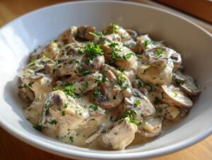 Close-up of a creamy mushroom sauce, featuring sliced mushrooms coated in a rich sauce and garnished with fresh parsley.