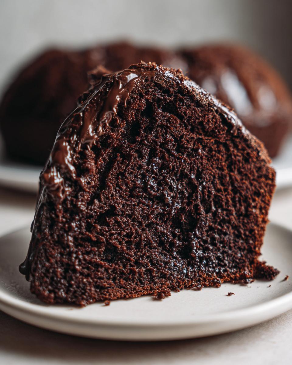 Close-up of a moist slice of hot fudge brownie bread with rich chocolate glaze dripping down the side.