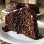Close-up of a moist slice of hot fudge brownie bread topped with rich, dripping chocolate fudge sauce.