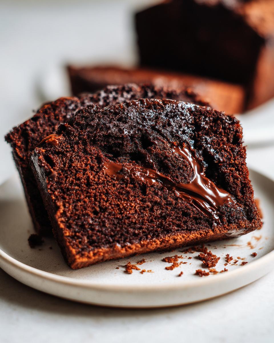 Close-up of two slices of moist hot fudge brownie bread showing a rich, gooey chocolate swirl inside.