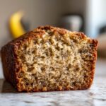 Close-up cross-section showing the moist, speckled crumb texture of the greek yogurt banana bread.