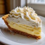 A perfect slice of creamy eggnog pie with a graham cracker crust and whipped topping dusted with nutmeg.