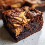 A close-up of a fudgy peanut butter swirl brownies square showing rich chocolate texture and golden peanut butter swirls.