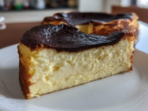 A close-up slice of creamy basque cheesecake showing its signature dark, caramelized top.
