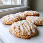 Close-up of several soft london fog cookies drizzled generously with white vanilla glaze.