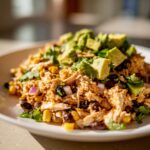 Close-up of a flavorful high protein salad featuring shredded chicken, black beans, corn, and diced avocado.
