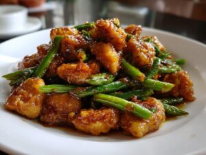 Close-up of crispy coated chicken pieces tossed with bright green beans in a savory brown sauce for chicken and green bean stir fry.