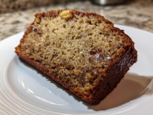 Close-up of a moist slice of banana bread for two showing a rich crumb and caramelized top.