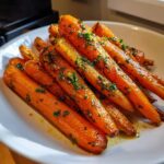Close-up of perfectly cooked Roast Honey Garlic Butter Carrots, glistening with glaze and topped with fresh parsley.