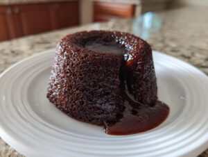 A freshly baked chocolate lava cake oozing rich, molten chocolate onto a white plate.